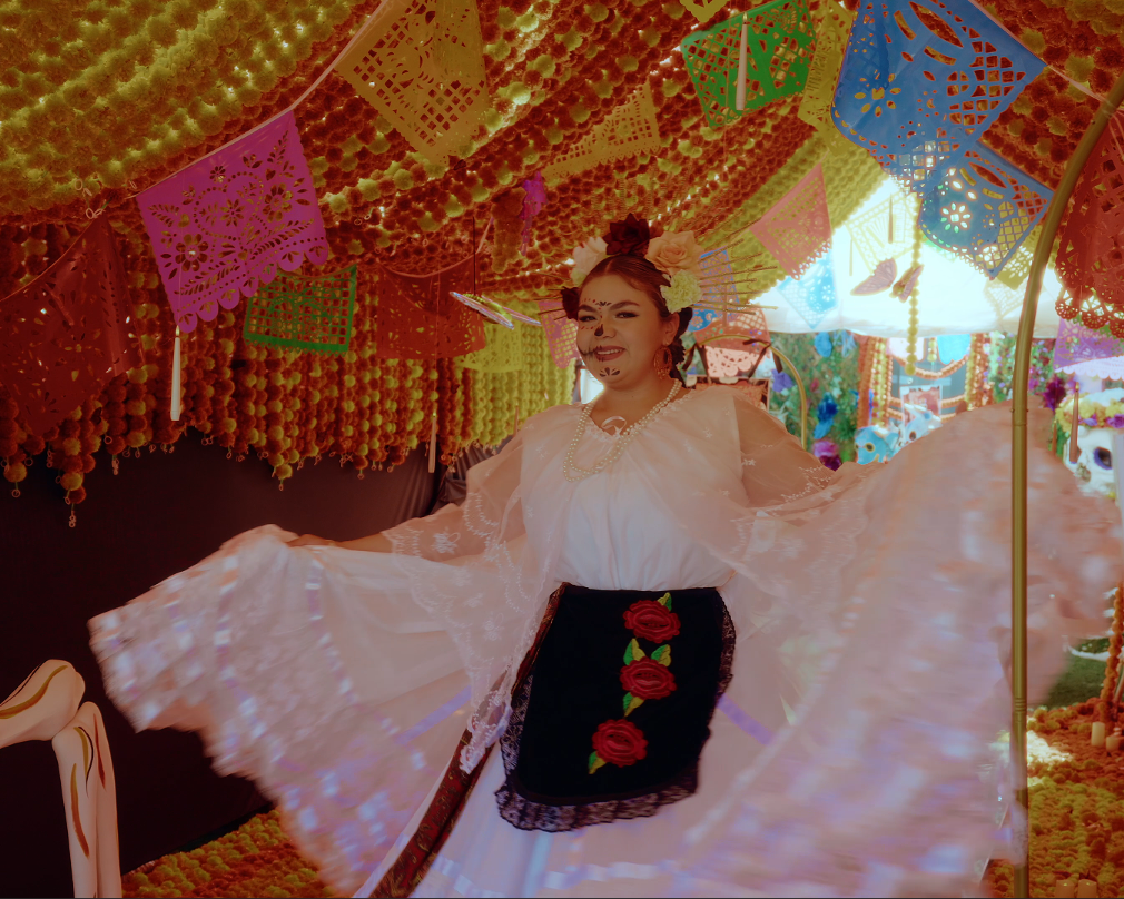 Woman in a white dress with a colorful, decorated ceiling in the background
